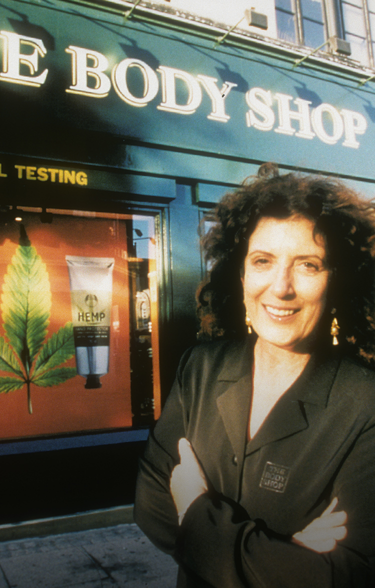 Anita Roddick, grunnleggeren av The Body Shop står foran en av de første butikkene