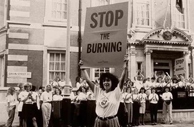 En aktivist holder oppe et skilt som leser "Stop The Burning"