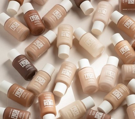 Kvinne som holder en Fresh Nude Foundation TAN